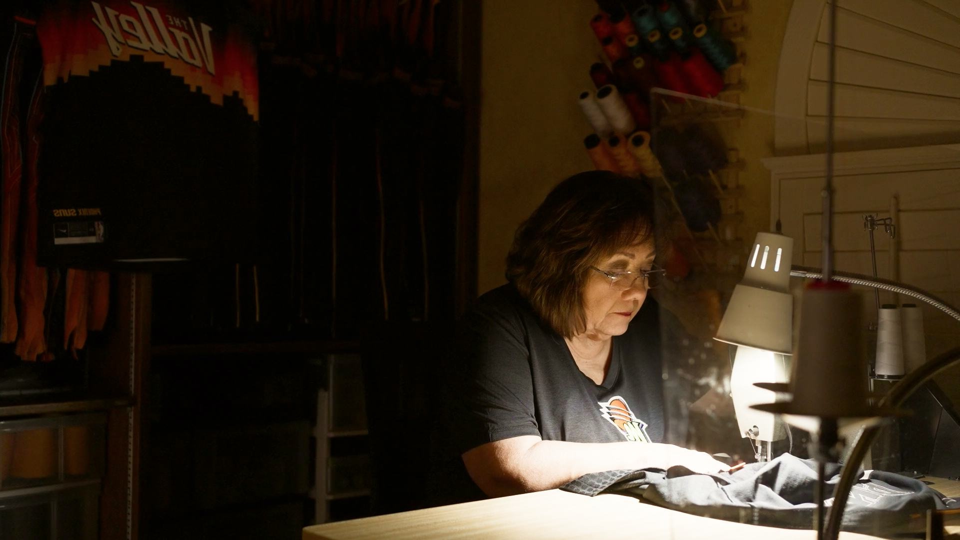 A woman sitting at a table with a lamp.