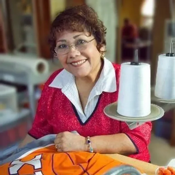 A woman sitting at a table with a tray of paper towels.